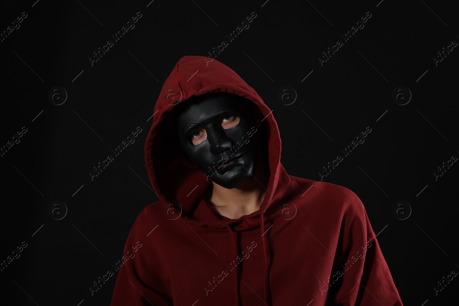 Photo of Anonymity. Man wearing mask on dark background
