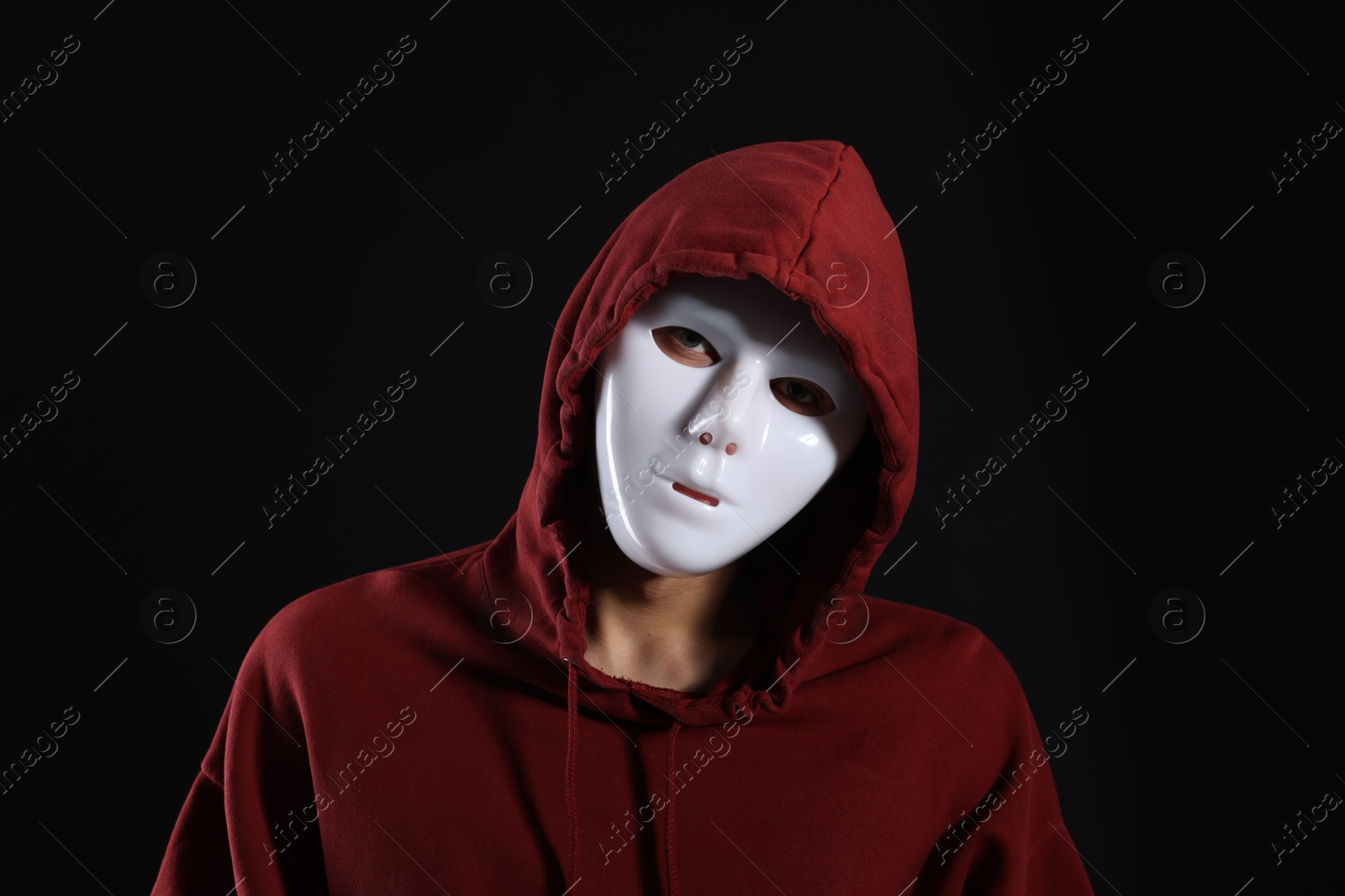 Photo of Anonymity. Man wearing mask on dark background