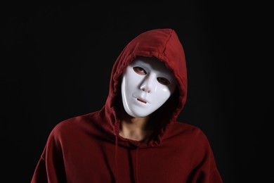 Photo of Anonymity. Man wearing mask on dark background