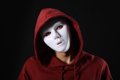 Photo of Anonymity. Man wearing mask on dark background