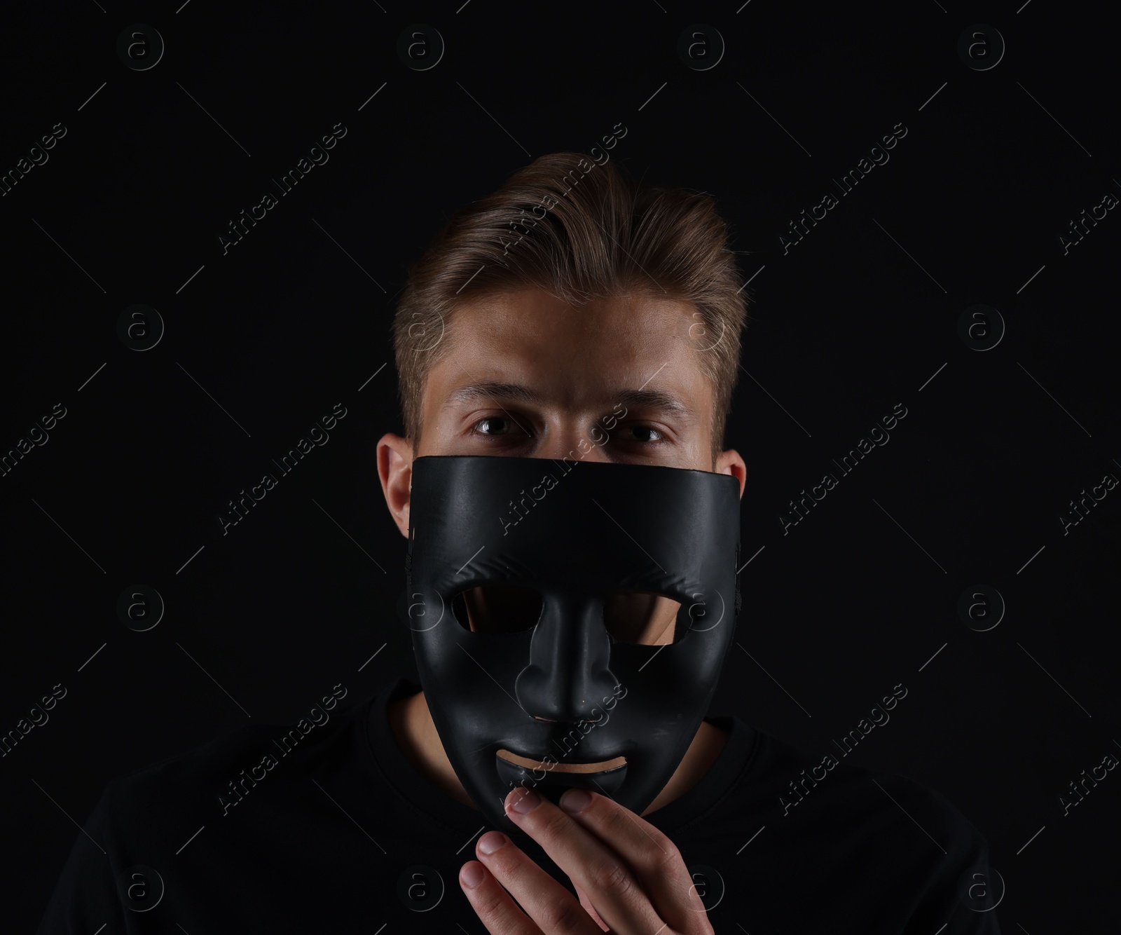 Anonymity. Man with mask on dark background Photo of Anonymity. Man with mask on dark background