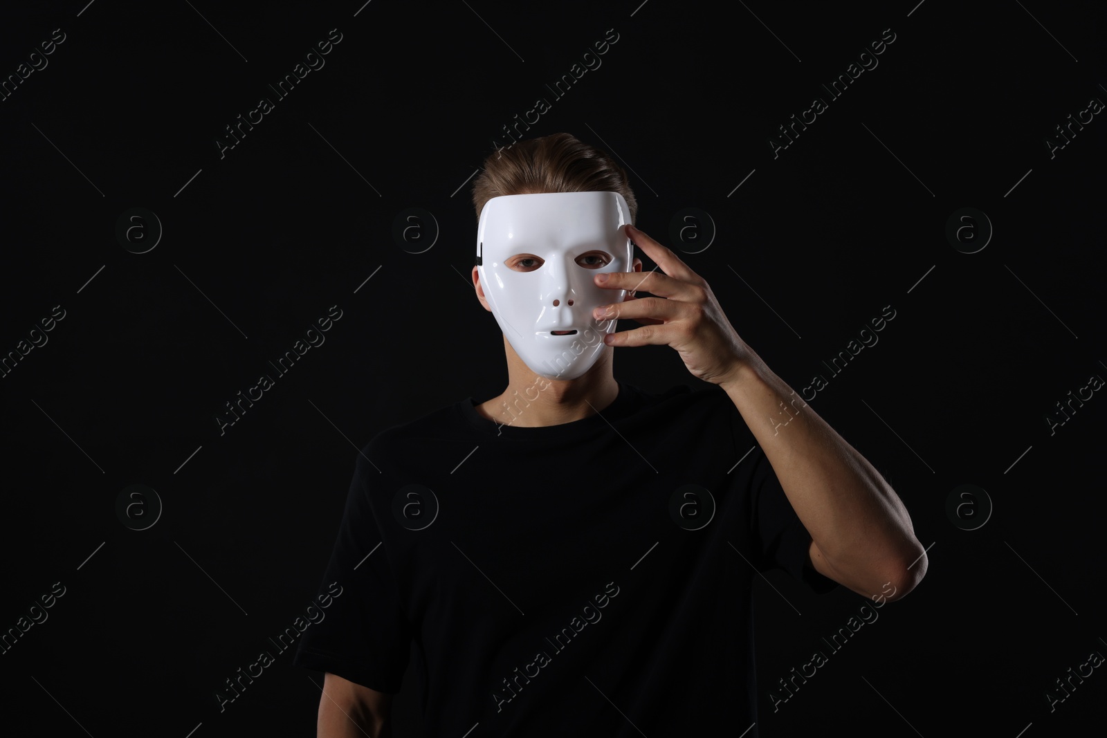Photo of Anonymity. Man wearing mask on dark background
