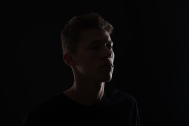 Photo of Anonymity. Portrait of young man in darkness