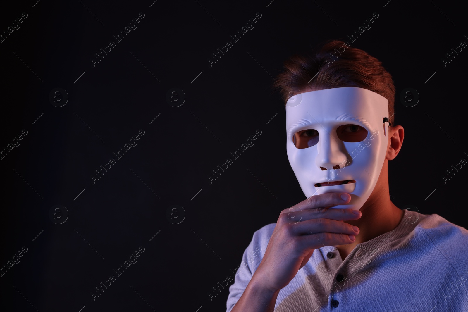 Photo of Anonymity. Man wearing mask on black background, space for text