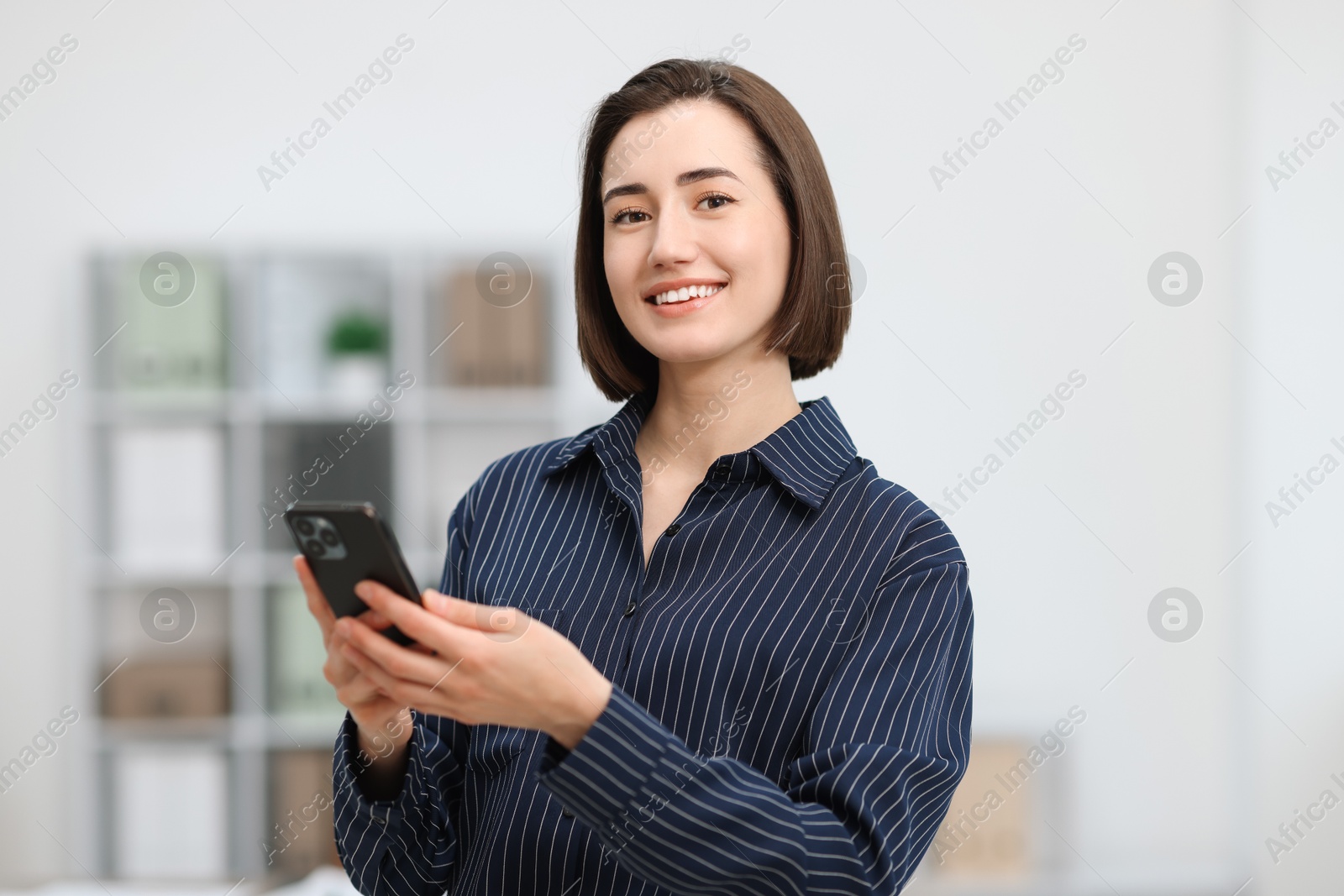 Photo of Beautiful woman using her smartphone in office