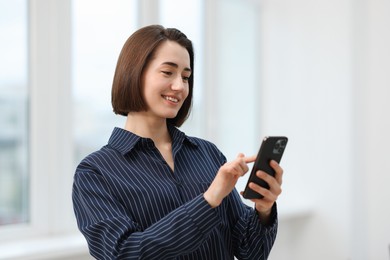 Photo of Beautiful woman using her smartphone in office
