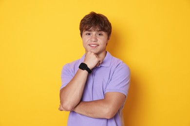 Photo of Portrait of smiling teenage boy on yellow background