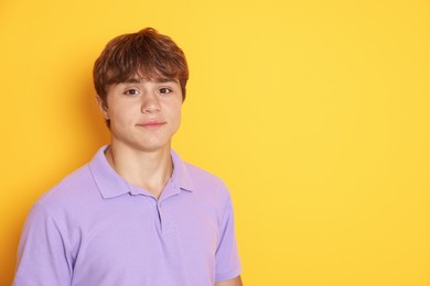 Photo of Cute teenage boy on yellow background. Space for text