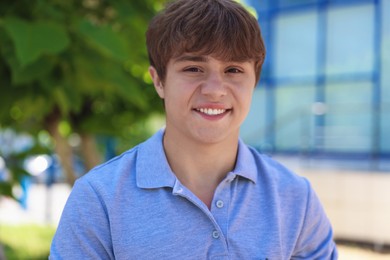 Photo of Portrait of smiling teenage boy on city street