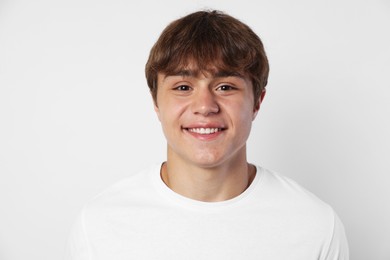 Photo of Portrait of smiling teenage boy on light grey background