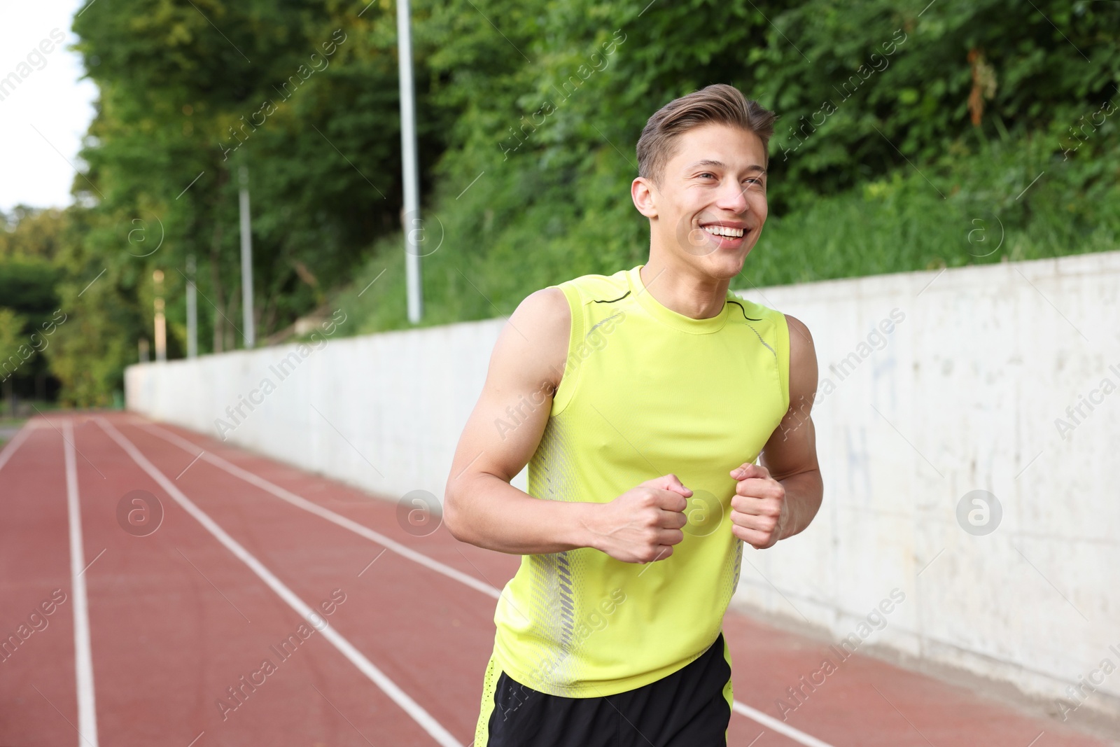 Photo of Sporty man running at stadium, space for text