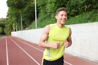 Photo of Sporty man running at stadium, space for text