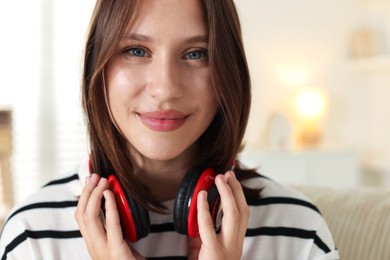 Photo of Portrait of beautiful teenage girl with headphones at home, closeup