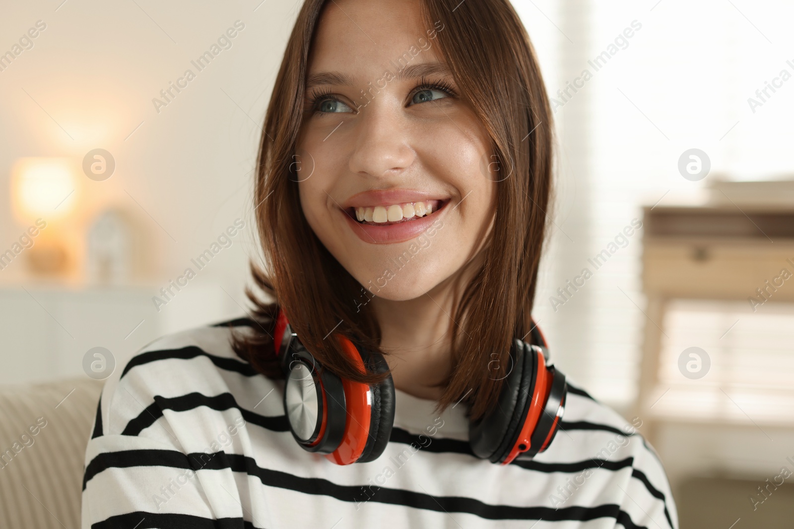 Smiling teenage girl with headphones at home Photo of Smiling teenage girl with headphones at home