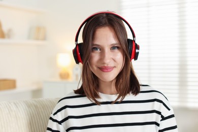 Photo of Portrait of beautiful teenage girl in headphones at home