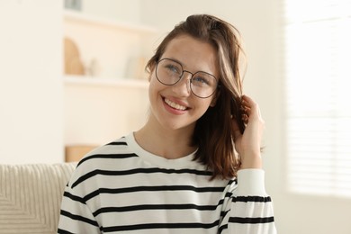 Photo of Smiling teenage girl in glasses at home