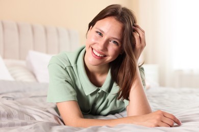 Photo of Portrait of smiling teenage girl on bed at home