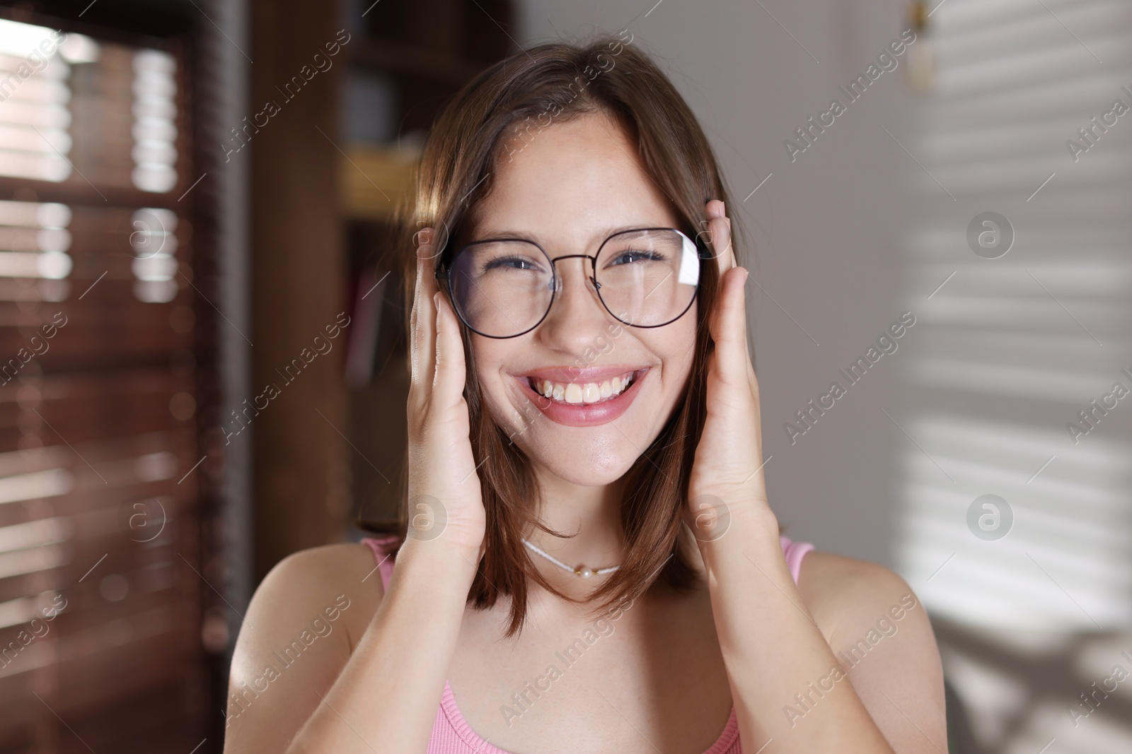 Portrait of smiling teenage girl in glasses at home Photo of Portrait of smiling teenage girl in glasses at home