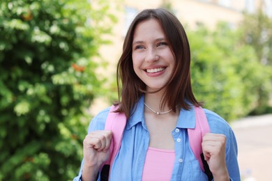 Photo of Portrait of smiling teenage girl on city street