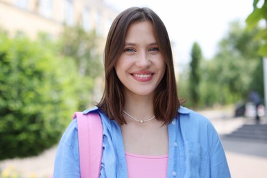 Photo of Portrait of smiling teenage girl on city street