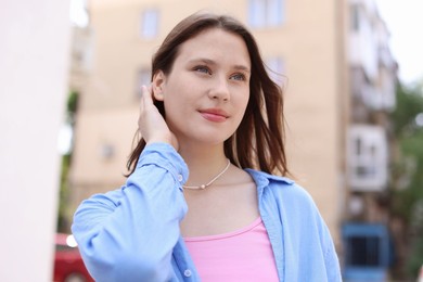 Photo of Beautiful teenage girl on city street, low angle view
