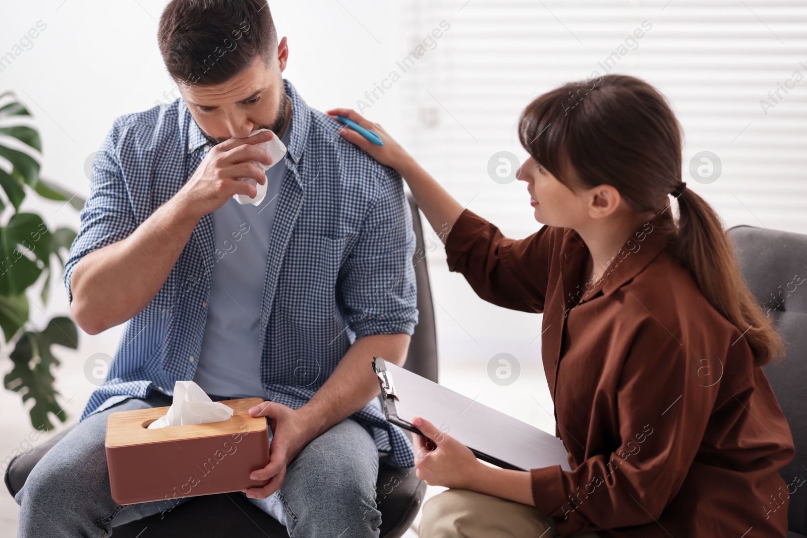 Photo of Psychologist supporting patient during therapy session in office