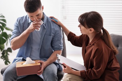 Photo of Psychologist supporting patient during therapy session in office