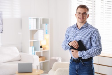 Photo of Portrait of smiling psychologist in glasses with notepad in office. Space for text