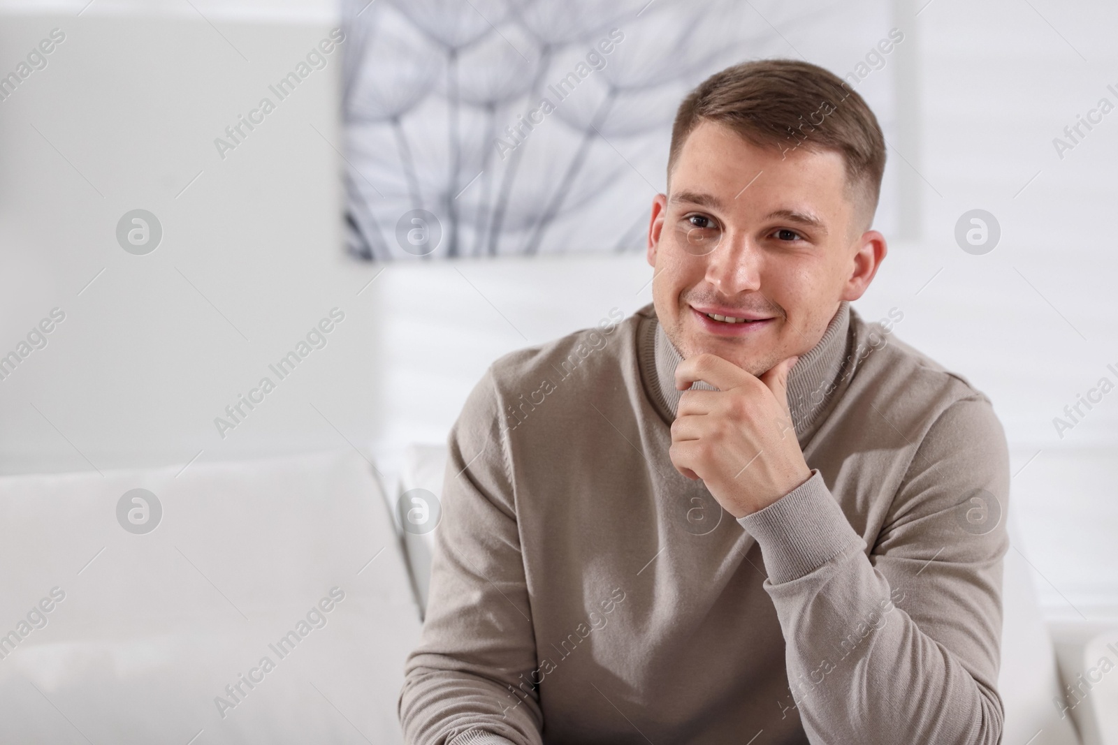 Photo of Smiling psychologist on sofa in office. Space for text