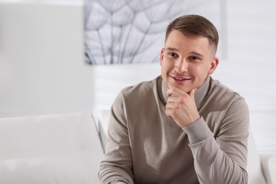 Photo of Smiling psychologist on sofa in office. Space for text