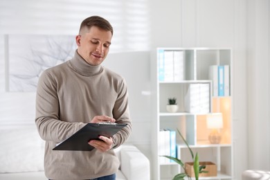 Photo of Smiling psychologist with clipboard in office. Space for text