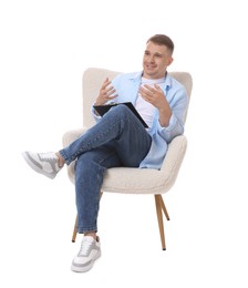Photo of Smiling psychologist with clipboard sitting on armchair against white background