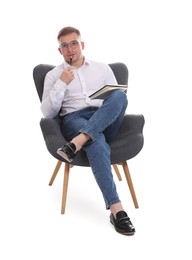 Photo of Thoughtful psychologist in glasses with notepad sitting on armchair against white background