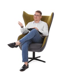 Photo of Smiling psychologist in glasses with clipboard sitting on armchair against white background