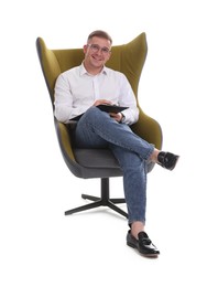 Photo of Smiling psychologist in glasses with clipboard sitting on armchair against white background
