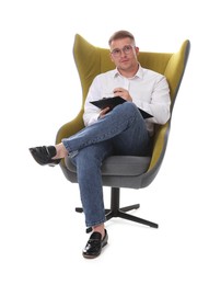 Photo of Psychologist in glasses with clipboard sitting on armchair against white background