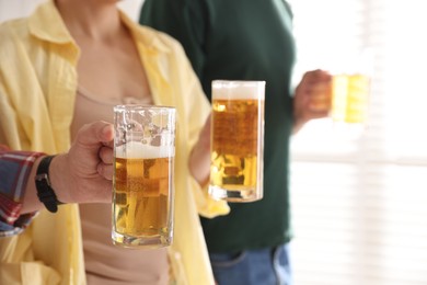 Photo of Friends with glass mugs of beer indoors, closeup. Space for text