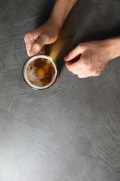 Photo of Man with glass mug of beer at grey table, top view. Space for text