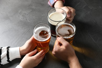 Photo of Friends with glasses of beer at grey table, above view