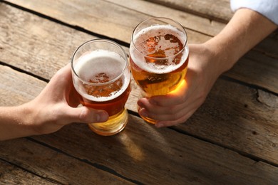 Photo of Friends with glasses of beer at wooden table, above view