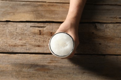 Photo of Man with glass of beer at wooden table, top view