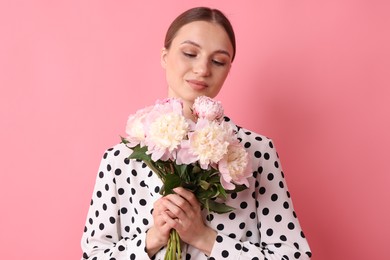 Photo of Woman with beautiful bouquet of peonies on pink background