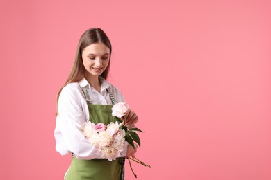 Photo of Florist with beautiful peonies on pink background, space for text