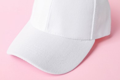 Photo of White baseball hat on pink background, closeup. Mockup for design
