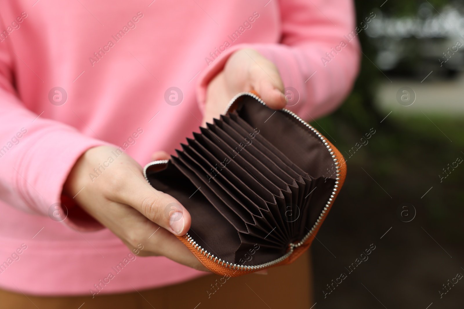 Woman with open empty wallet outdoors, closeup Photo of Woman with open empty wallet outdoors, closeup