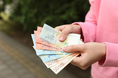 Photo of Woman counting her money outdoors, closeup view
