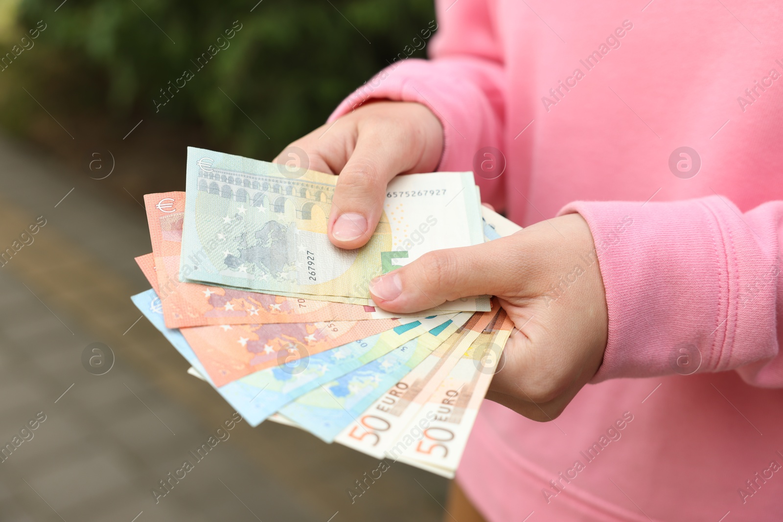 Woman counting her money outdoors, closeup view Photo of Woman counting her money outdoors, closeup view