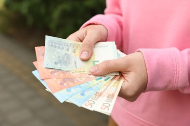 Photo of Woman counting her money outdoors, closeup view