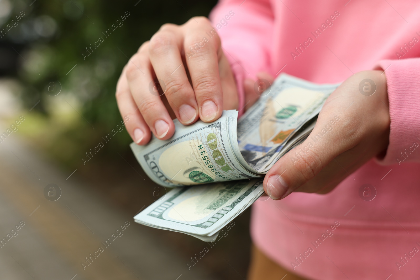 Woman counting her money outdoors, closeup view Photo of Woman counting her money outdoors, closeup view