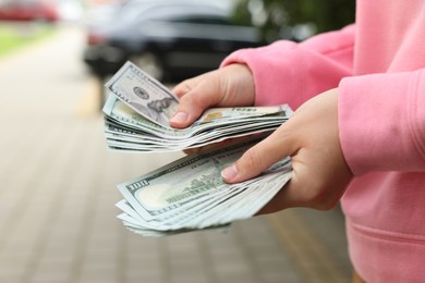 Photo of Woman counting her money outdoors, closeup view